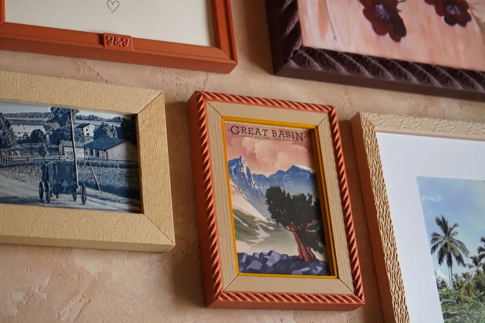 A wall of printed frames: wood grain, rope edge relief, hammered texture, and a raised monogram
