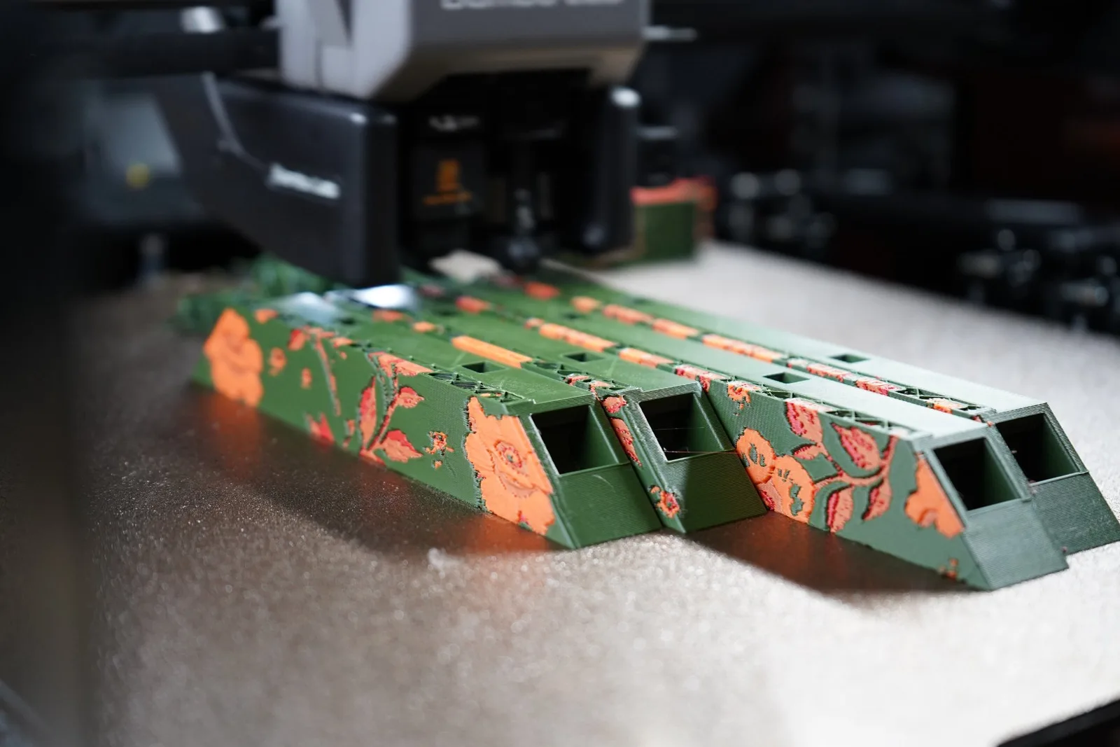Colorized frame pieces coming off the printer: green edges with orange florals