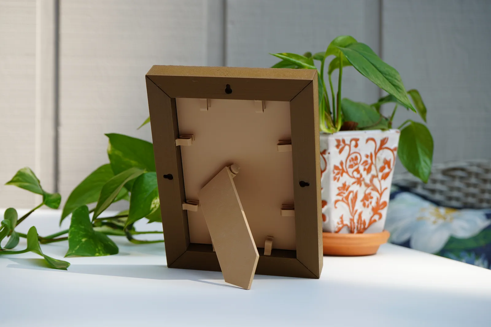 The back of the same frame: backer plate held by clips, with the kickstand out